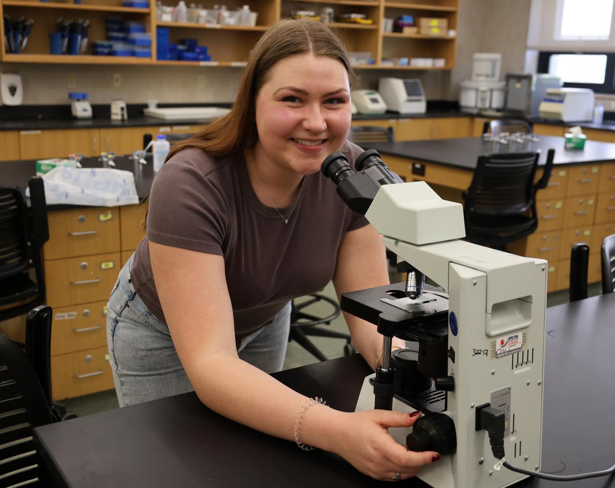 student looking through a microscope