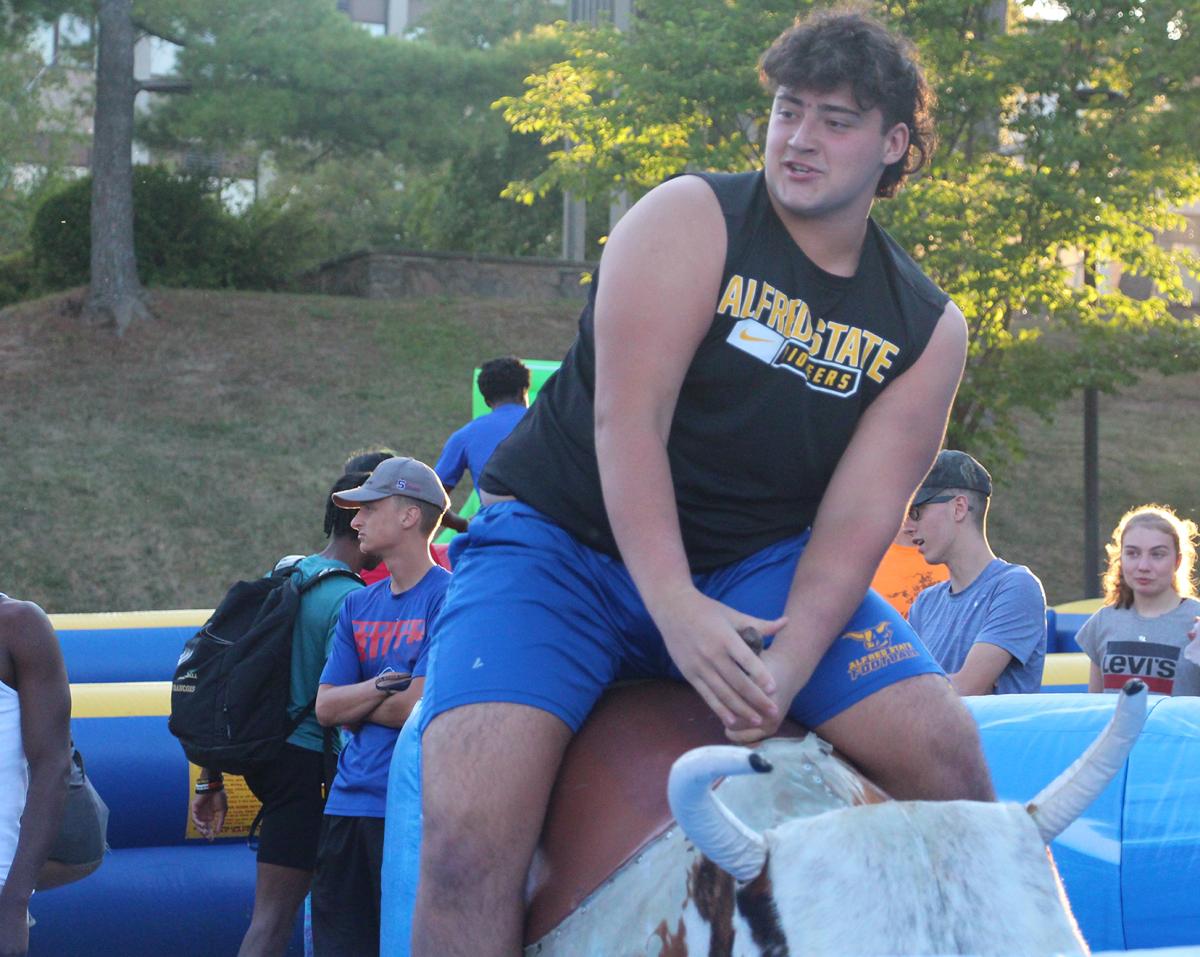 An Alfred State student rides a mechanical bull during the annual Week of Welcome carnival