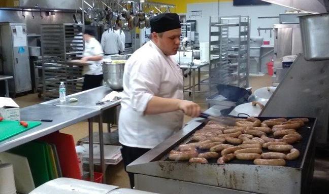 A culinary arts students works on the grill