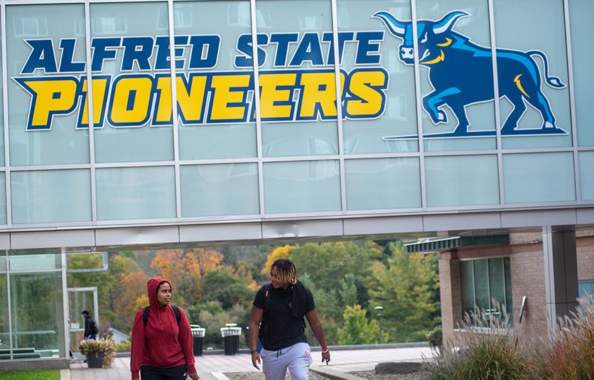 students walking on campus near the Student Leadership Center bridge