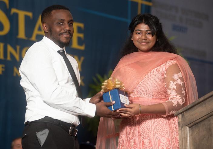 Tyler Richards, the Residence Hall Director in Braddon Hall, receives the Alfred State Student Advocate Award from Student Senate President Soumya Konar.