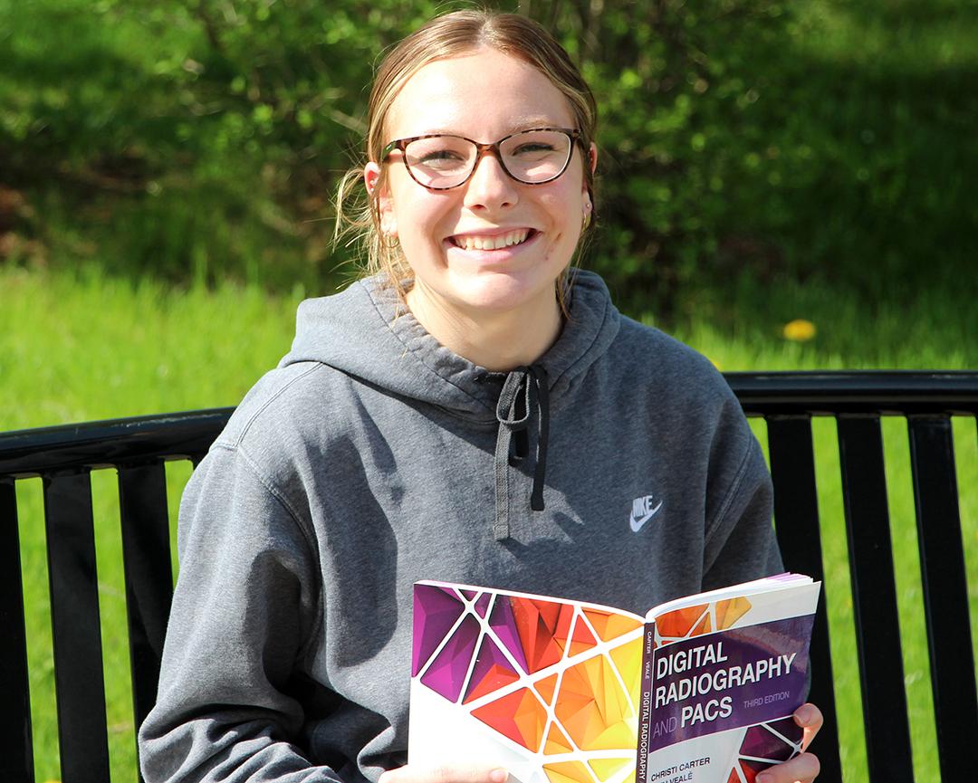 Andi Williamson, who received a scholarship to attend Alfred State, studies outside the Hinkle Library.