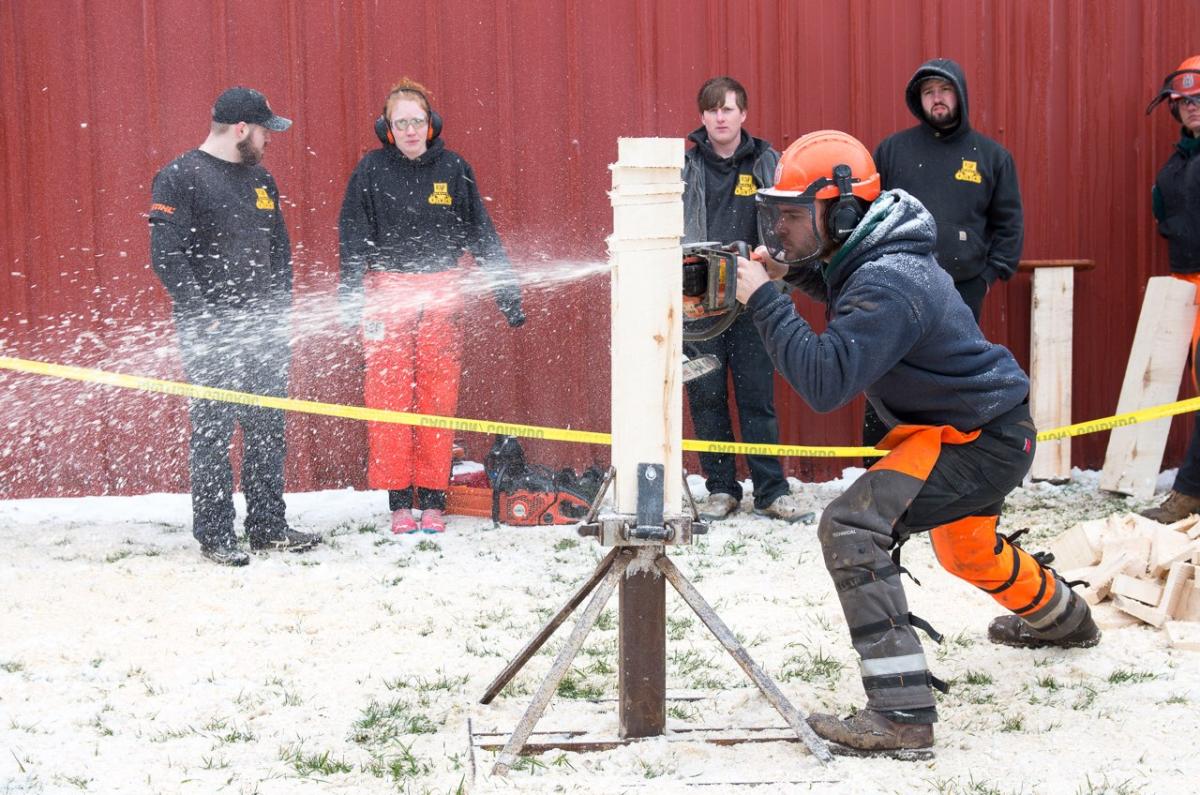 student competes in a timber sports event
