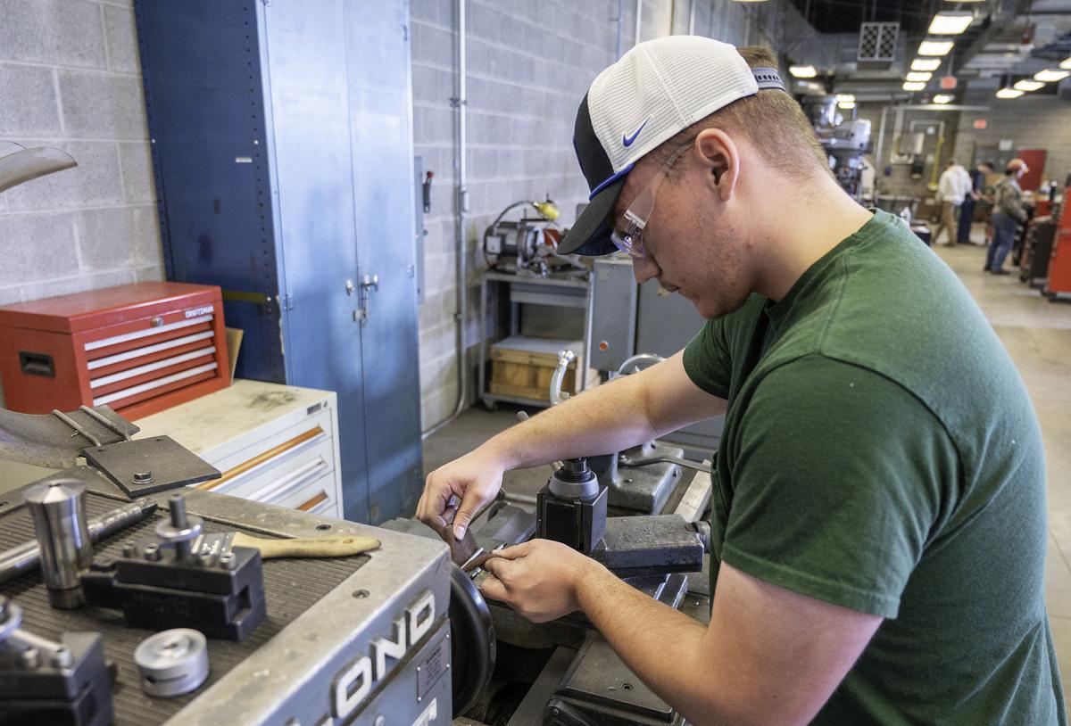 student works on a CNC machine