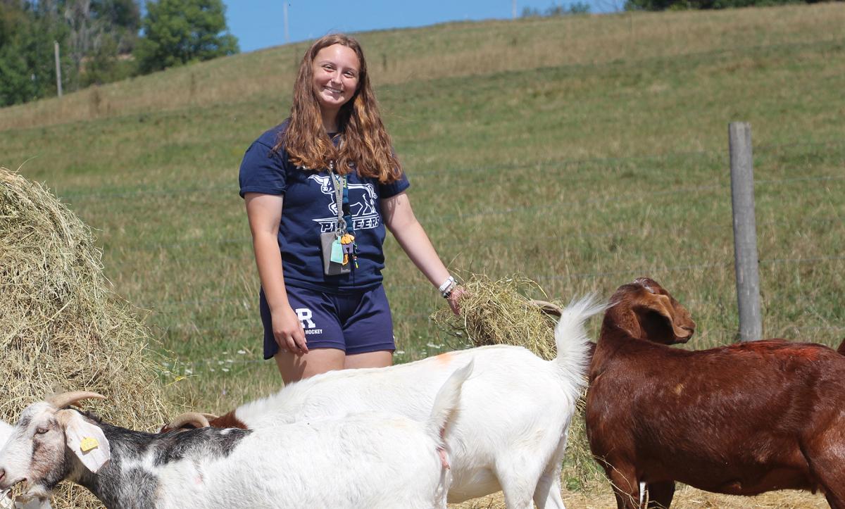 smiling student with the goats on the ASC farm