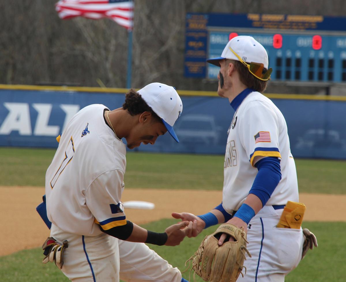 Alfred State baseball players Elijah Barinas and Devin Mersmann celebrate the end of an inning during a game earlier in the season.