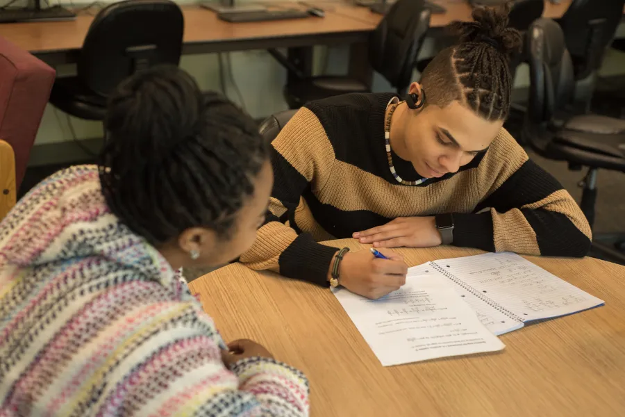 A student reviewing papers with a faculty mentor.