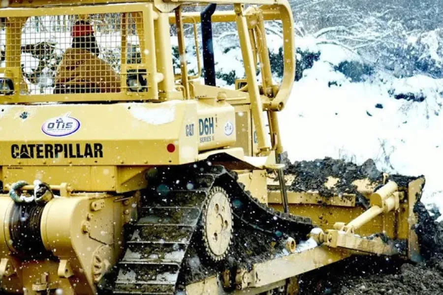 Person operating Caterpillar bulldozer outside in the winter.
