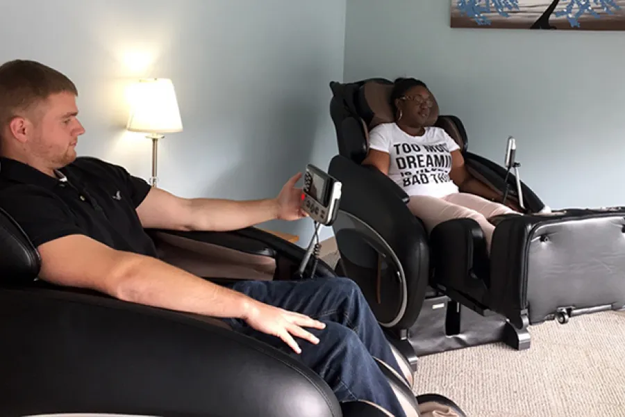Two students sitting in massage chairs