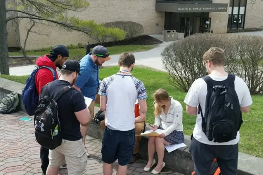 Students on campus outside working on schoolwork.