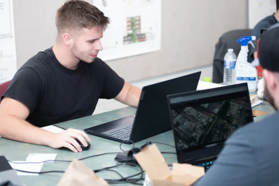 two students working on laptops