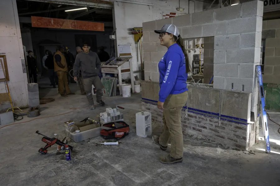 A student standing in front of a wall in a construction area