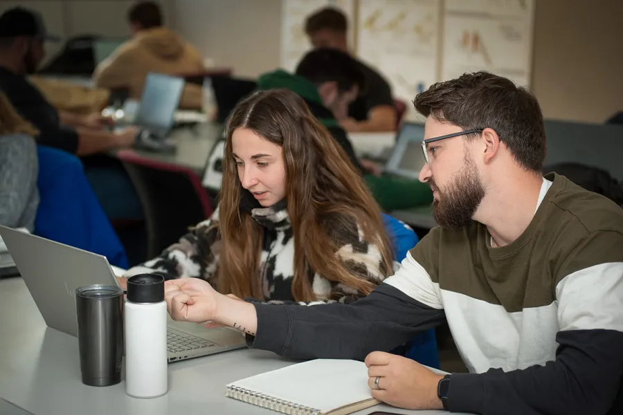 A professor working on a computer with a student