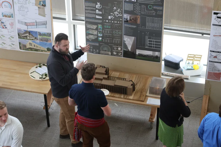 People looking at exhibits of architectural models.