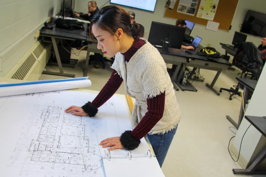 A student reviewing blueprints