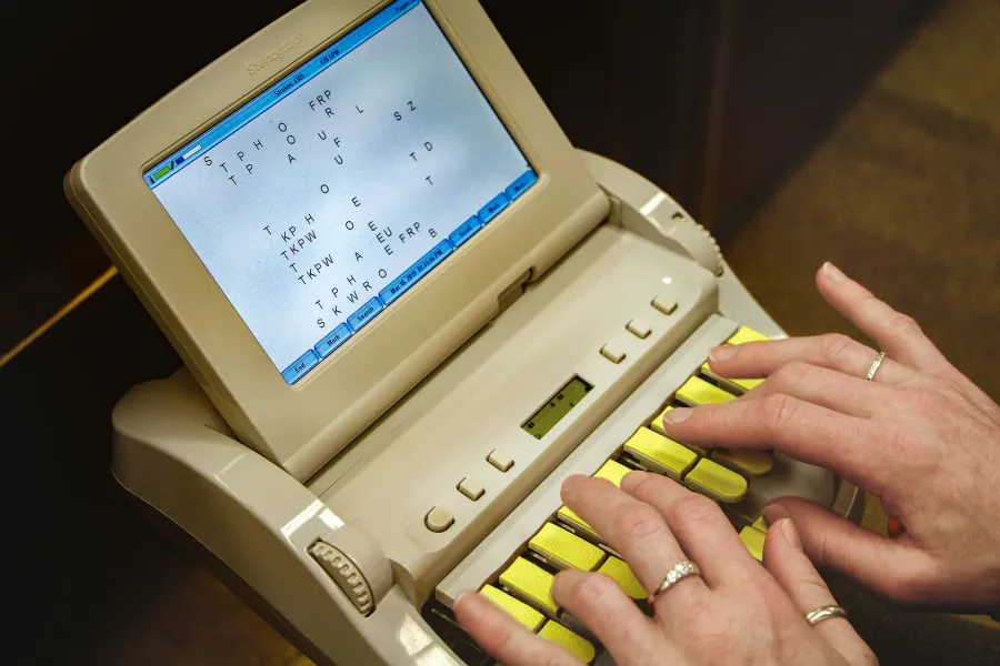 Close up image of someone using a stenotype machine.