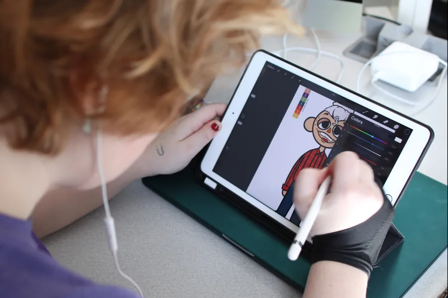 A student drawing a character on an iPad
