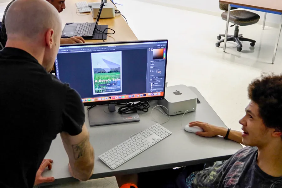 A student and professor reviewing a design on a computer