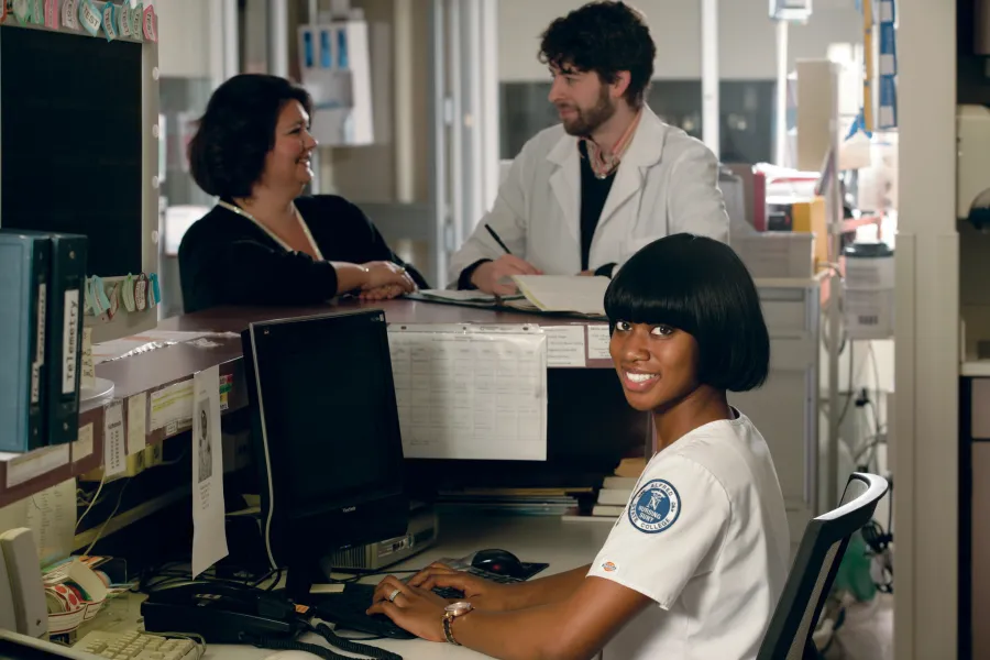 Three healthcare professionals working at a desk.