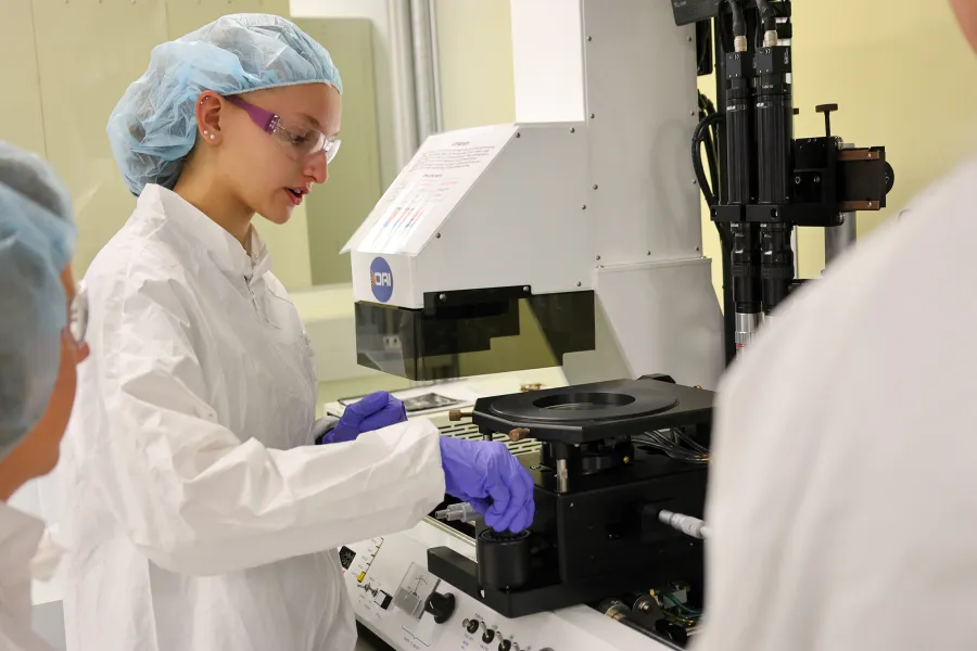 A student in safety working gear working in a cleanroom lab