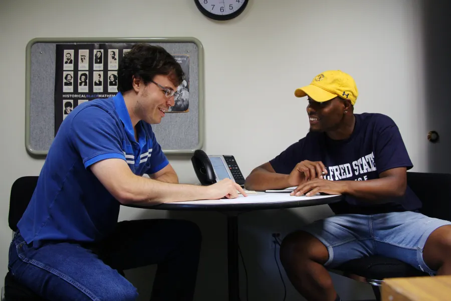 A student and advisor discussing at a table