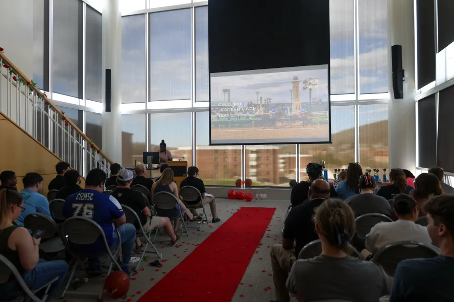 Students in a small even space sitting in rows of seats
