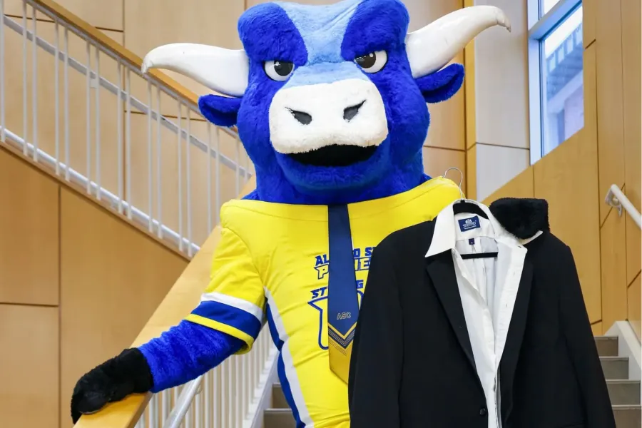 Photo of Big Blue with a suit in hand on the SLC stairwell.