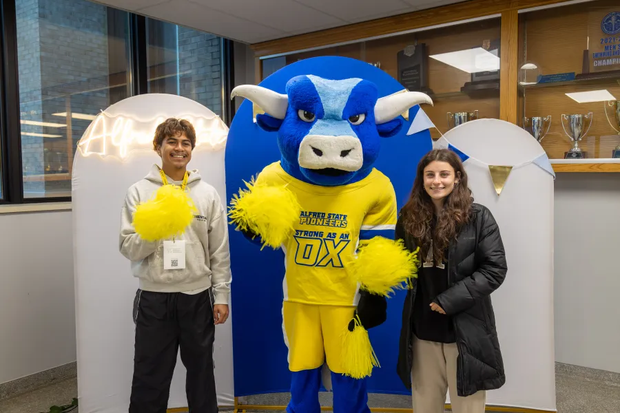 Big Blue with 2 students holding pom poms