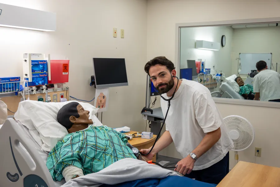 A student nurse practicing care for a manikin 
