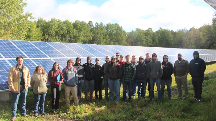 Tyler Uebelhoer stands with a class of Electrical Construction and Maintenance Electrician students at Alfred Community Solar after showing the class the set-up of the new Buffalo Solar project.