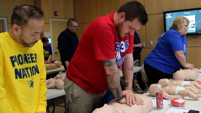 Alfred State Admissions Counselor Doug Tay (middle of picture) practice CPR compressions during a training session. 40 Alfred State employees attended the CPR/AED class held during the college Professional Development Week.