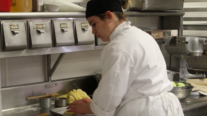 An Alfred State Culinary Arts student works in the kitchen.