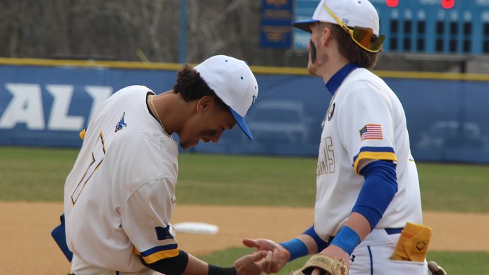 Alfred State baseball players Elijah Barinas and Devin Mersmann celebrate the end of an inning during a game earlier in the season.
