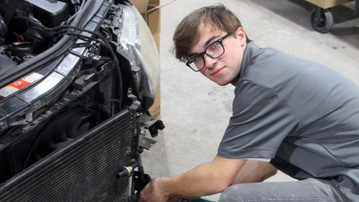 Student works on repairing a car