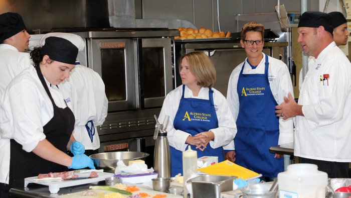 Photo of Alfred State Vice President of Academic Affairs Carrie Cokely and Vice President of Enrollment Management Kishan Zuber have a recipe for success with new recruitment numbers. Seen here visiting a culinary arts class on the Wellsville campus.