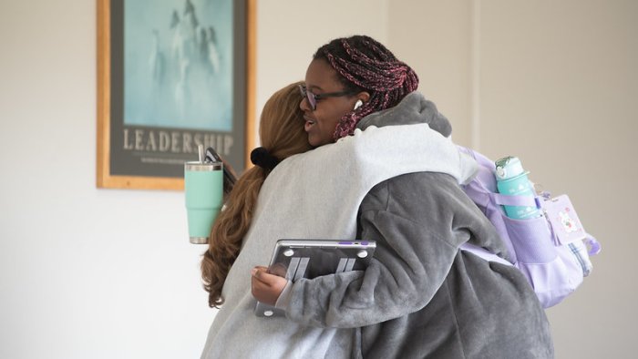 Students hug outside a classroom