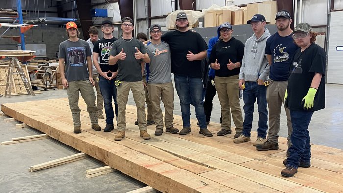 Building trades students stand on a bridge they constructed