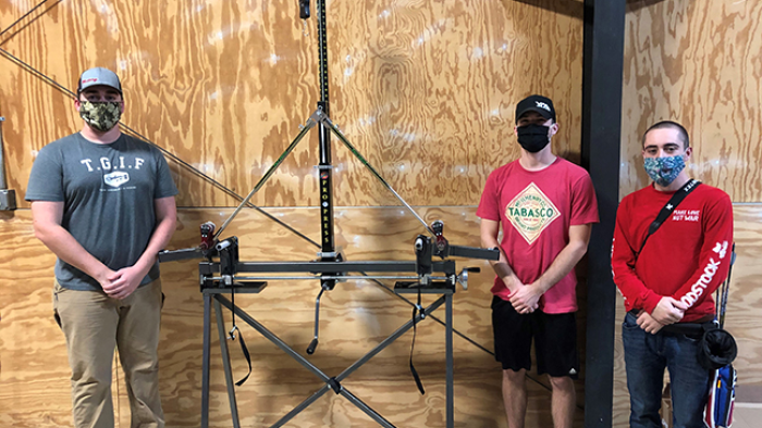 Archery Team Members With Bow Press