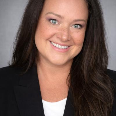 A professional headshot of Lynn Brennan White with long dark hair