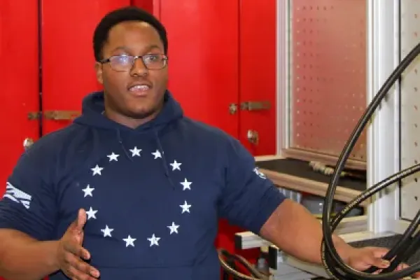 Student standing next to engineering machinery