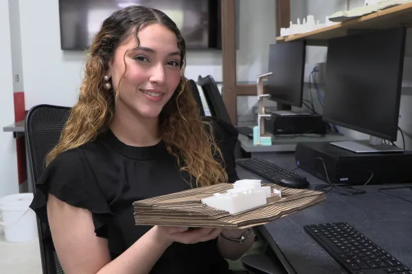Student smiling while sitting in a studio.
