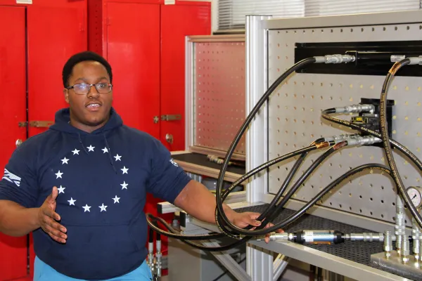 Student standing next to engineering machinery