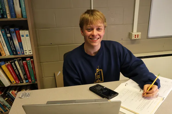 student works on math problems at a desk