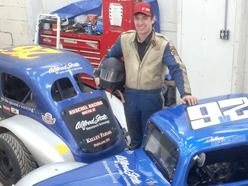 Anthony Riforgiato standing next to two cars
