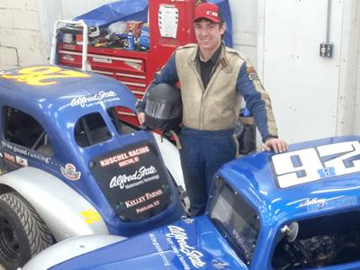 Anthony Riforgiato standing next to two cars