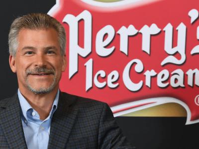 Brian Perry standing in front of Perry's Ice Cream logo