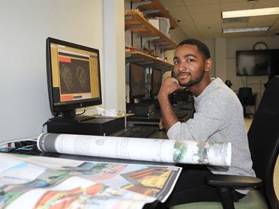 Caleb Boyce-Wright sitting at a desk with computer and papers