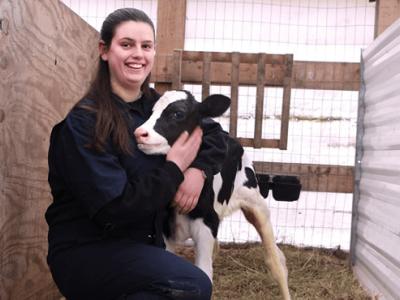 Caroline hugging a calf on the farm