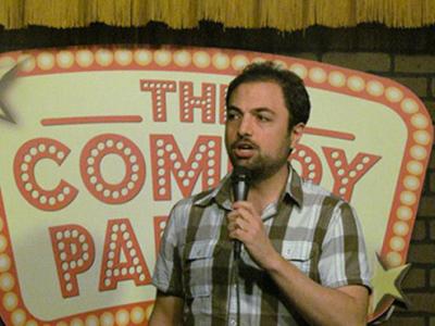 Chad Dispenza at the comedy club, holding a microphone