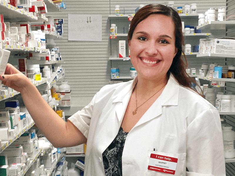 Courtney Cardinal in a pharmacy wearing a lab coat